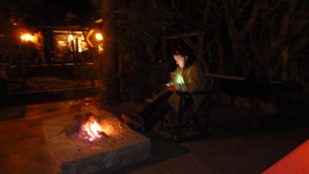 Erin and her iPad sitting around the fire pit at River Lodge