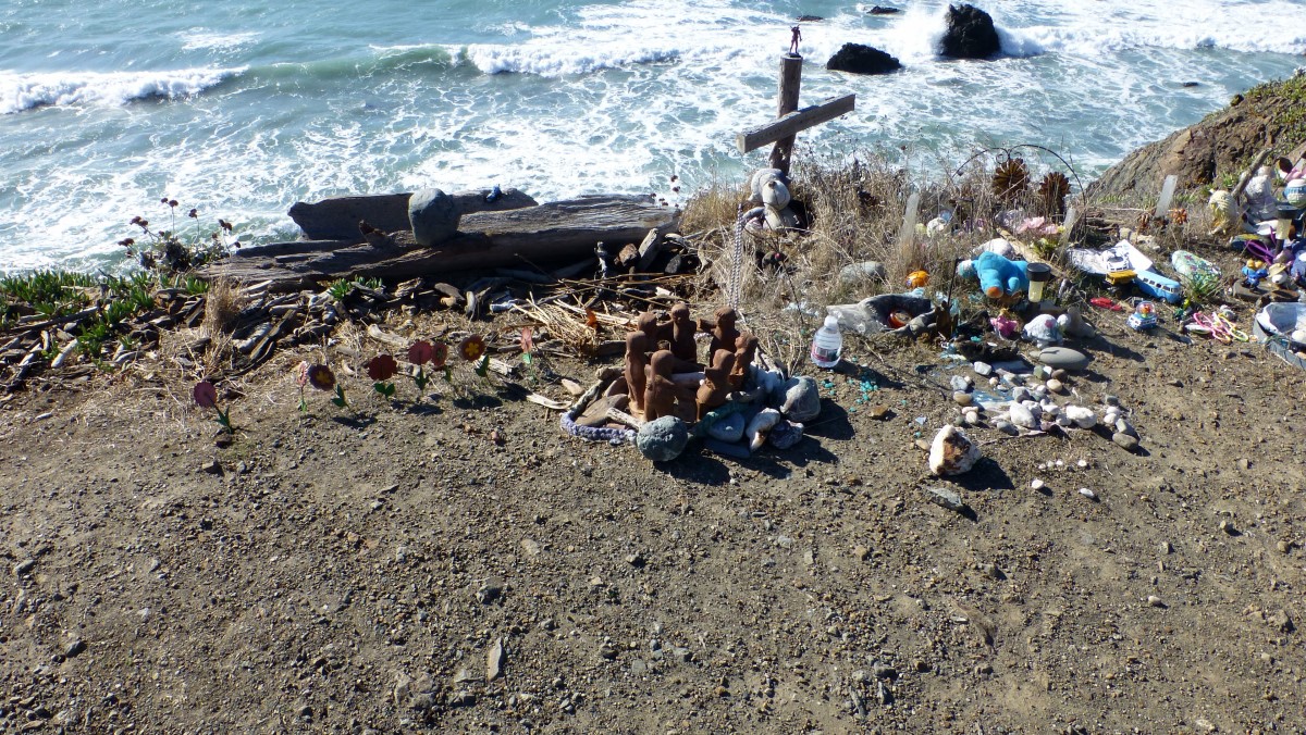 It appears to have become the custom to leave odd trinkets and doodads at interesting locations as a kind of a shrine. At this pull-<wbr>off over-<wbr>looking the Pacific, you can see, among other things, stuffed animals, sea shells, a water bottle and a cross with a plastic figure on it. I think the little circle of clay people holding hands adds a nice touch.